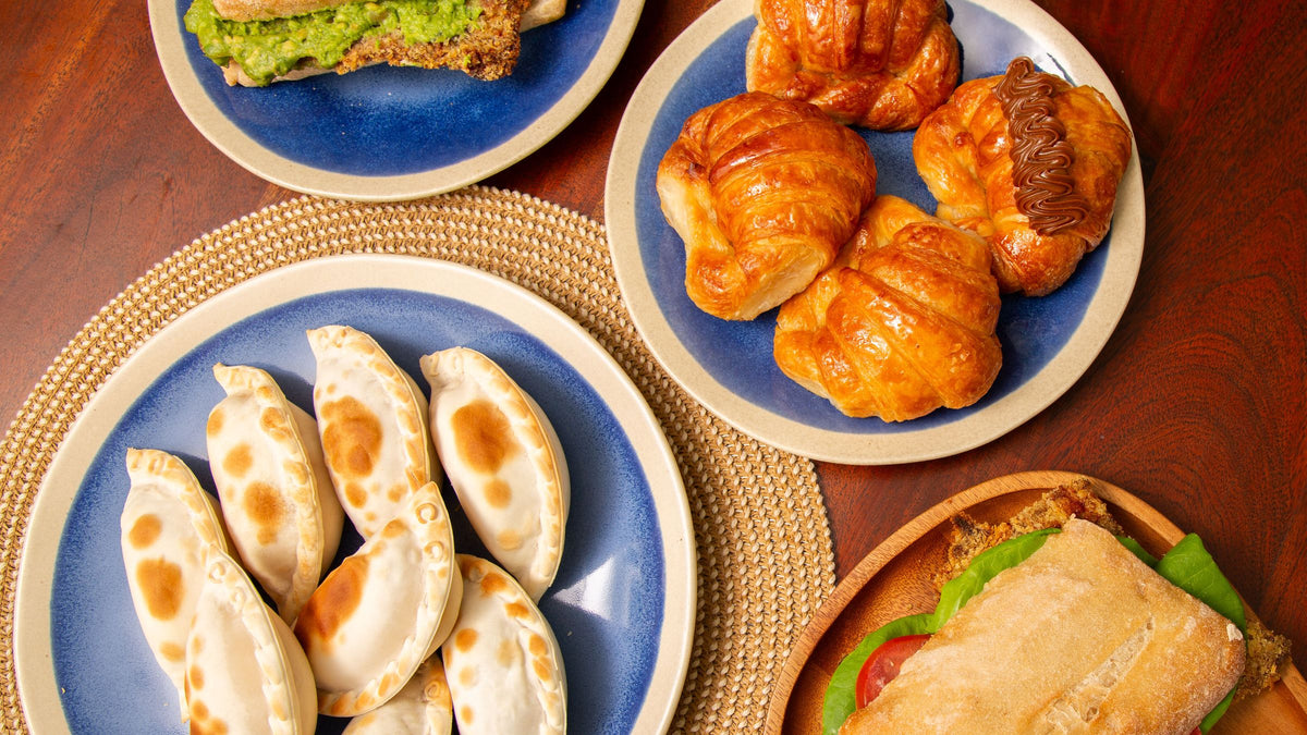 Mesa con empanadas, medialunas y sándwiches de milanesa para compartir