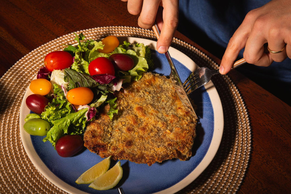 Milanesa dorada con ensalada fresca en un plato